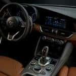 interior of a 2020 Alfa Romeo Nero Edizione with brown and black leather and chrome details throughout the cabin