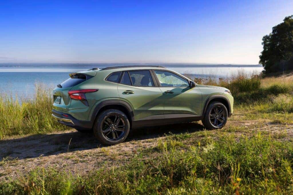 Passenger’s side view of Chevrolet Trax ACTIV in Cacti Green parked in front of a lake. Pre-production model shown. Actual production model may vary. Available in spring 2023. Cacti Green exterior color late availability.