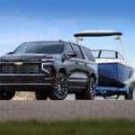 Front 3/4 shot of the 2025 Suburban High Country towing a boat