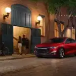 Red Chevrolet Malibu parked on a quaint street with lighting