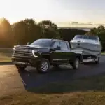 Chevrolet Silverado 2500HD towing a boat from the lake at sunset