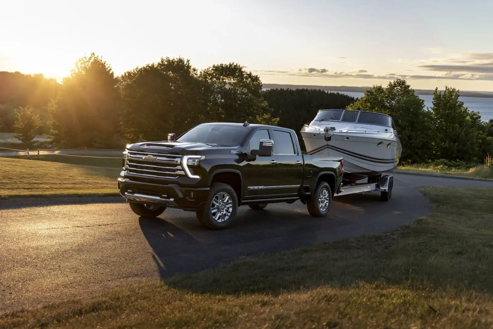 Chevrolet Silverado 2500HD towing a boat from the lake at sunset
