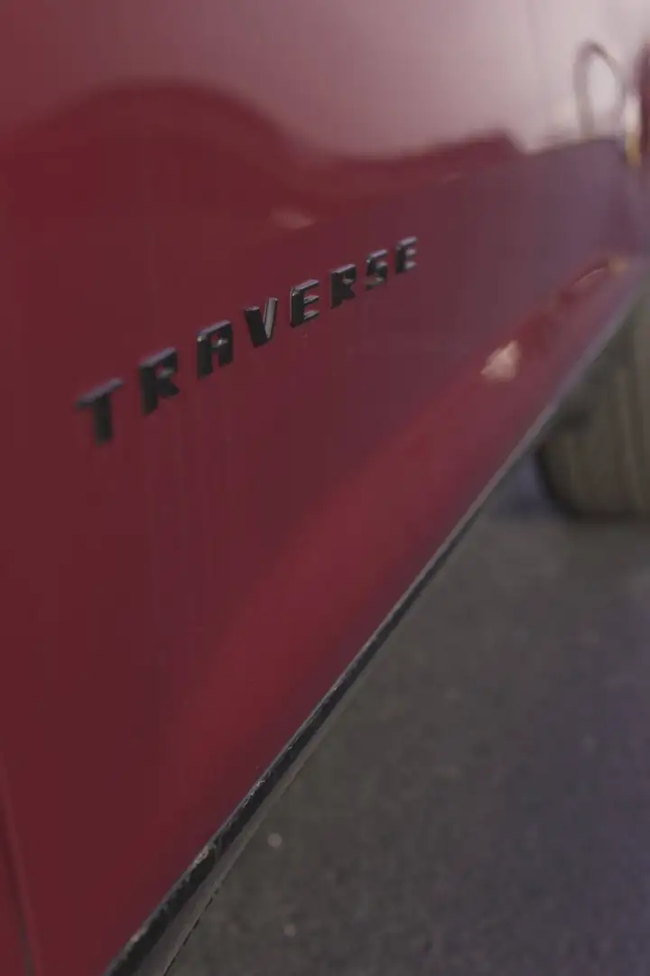 Close-up side view of a maroon red Chevrolet Traverse door badge at Barry's Chevrolet in West Union, OH