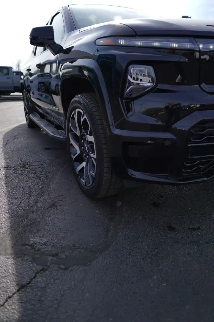 Low-angle front corner view of a black Chevrolet Silverado EV electric truck at Barry's Chevrolet dealership in West Union, OH