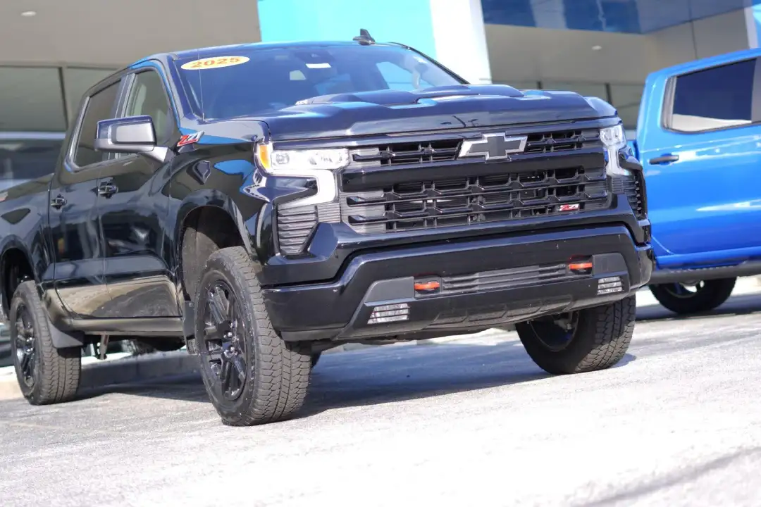 Low-angle front view of a black 2025 Chevrolet Silverado 1500 Custom Trail Boss truck at Barry's Chevrolet in West Union, OH