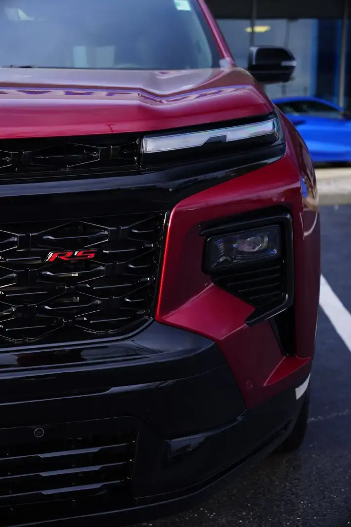 Close-up front view of a maroon red Chevrolet Traverse RS SUV grille at Barry's Chevrolet in West Union, OH