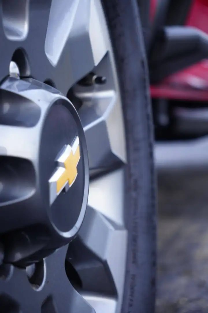 Close-up of a grey Chevrolet truck alloy wheel featuring the gold bowtie logo on the center cap