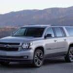 The Reliable And Battery Efficient 2020 Chevrolet Suburban, Parked In Front Of Beautiful, Vast Mountains