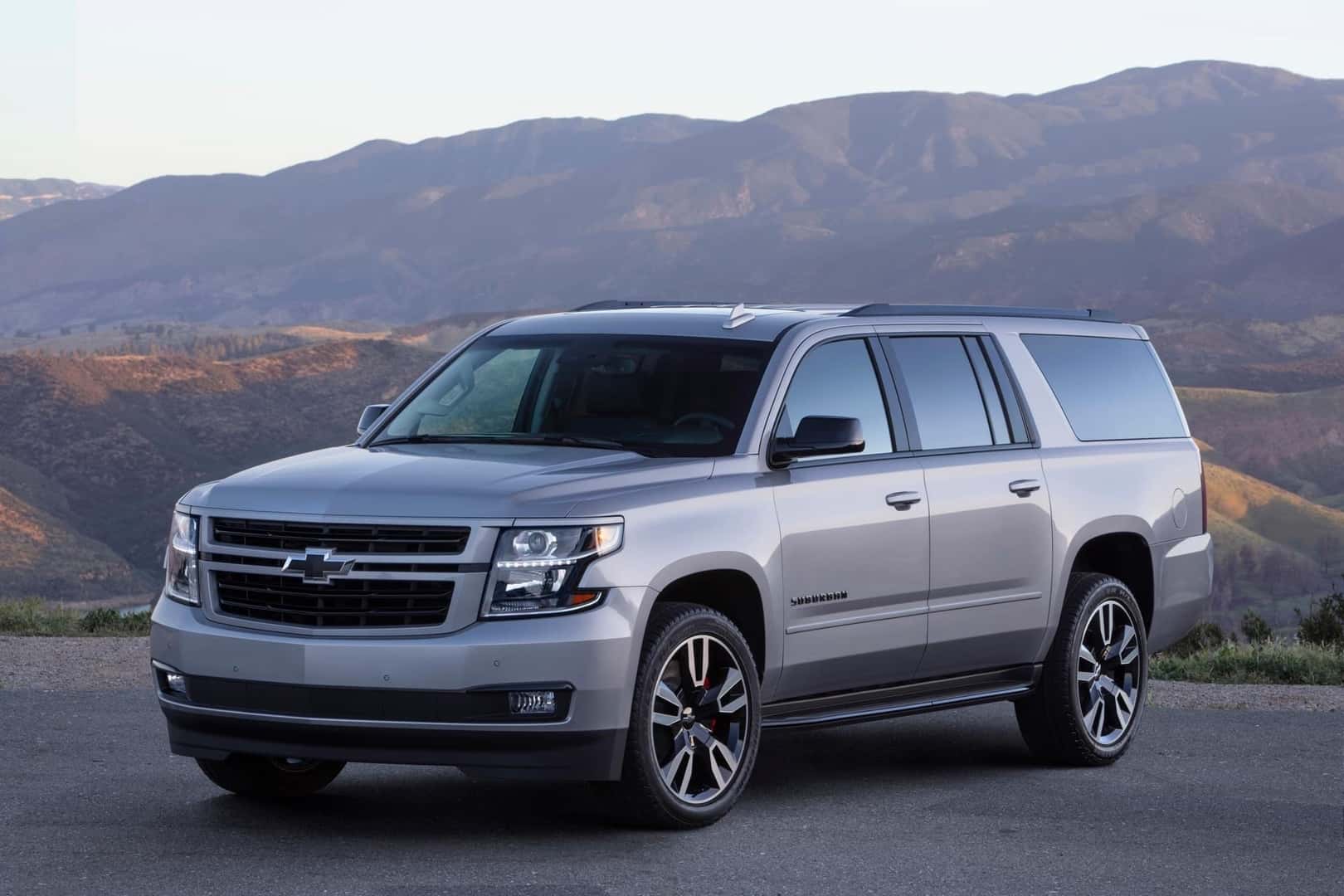 The Reliable And Battery Efficient 2020 Chevrolet Suburban, Parked In Front Of Beautiful, Vast Mountains
