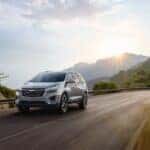 The Fabulous 2023 Chevrolet Equinox Riding Away As The Sun Rises Above A Magnificent Mountain