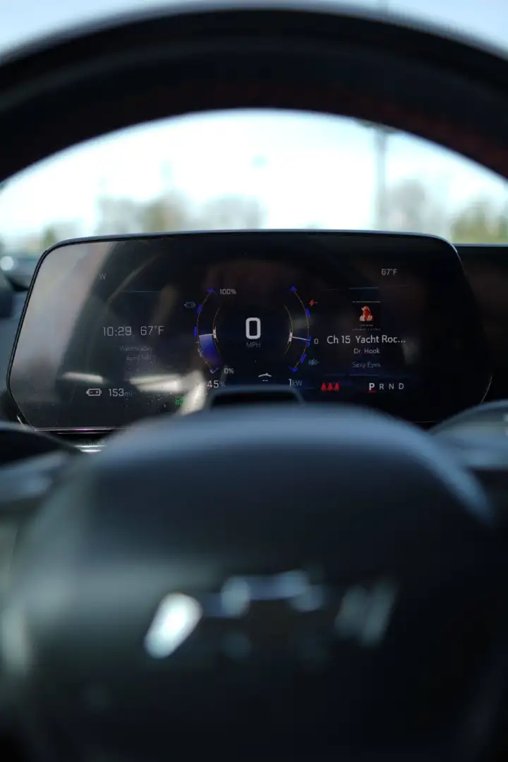 Digital speedometer and dashboard display inside a Chevrolet EV, framed by the steering wheel