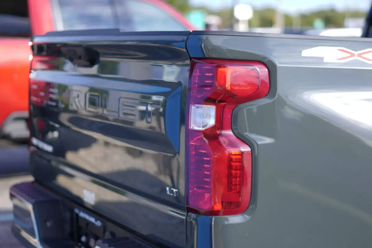Close-up of an olive green Chevrolet Silverado tailgate with an LT badge and red vertical taillight