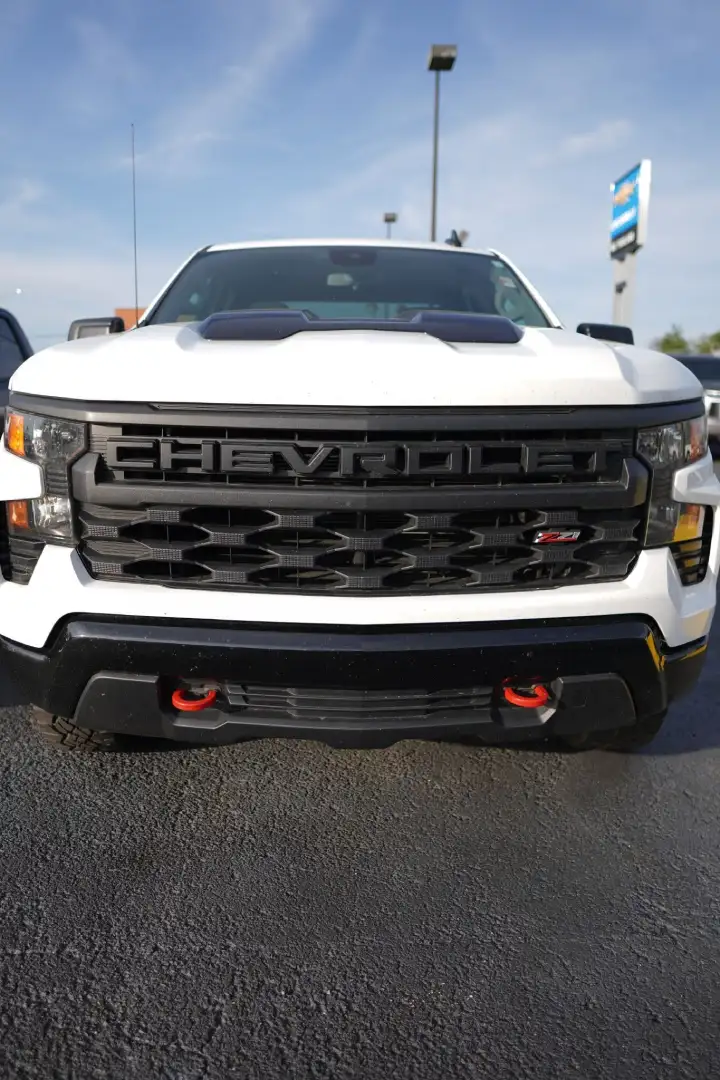 Close-up of a white Chevy Silverado front bumper showing a black CHEVROLET grille and red Z71 badge