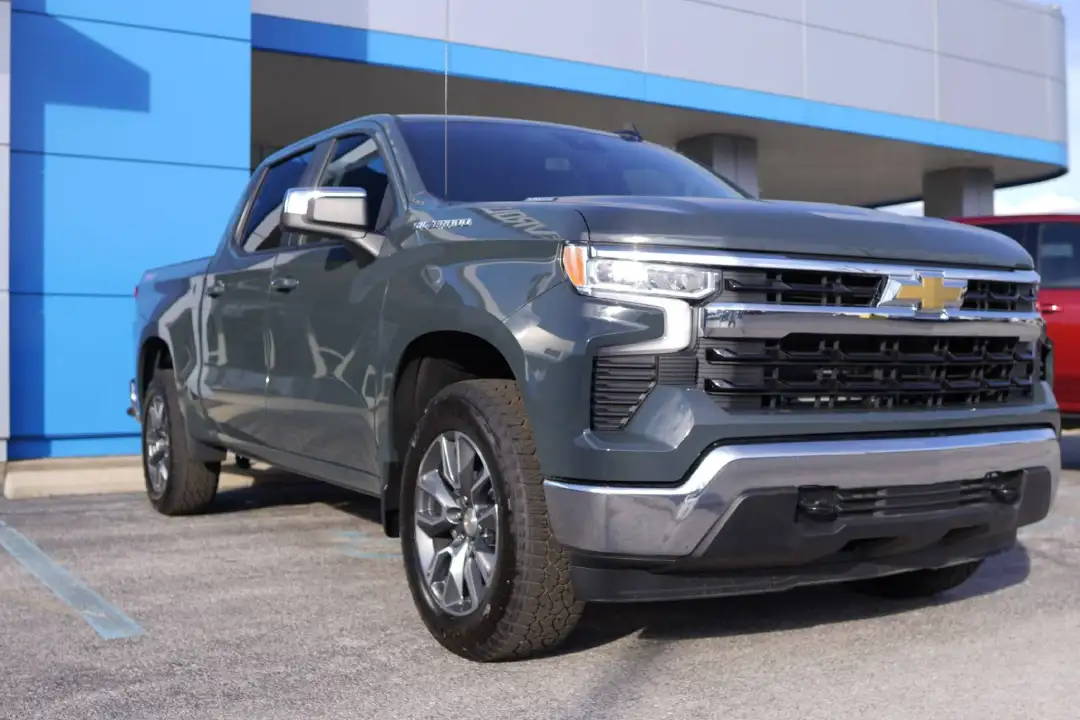 A gray Chevrolet Silverado 1500 crew cab pickup truck parked on the lot at Barry's Chevrolet dealership