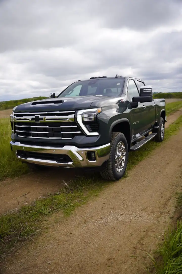 A dark grey Chevrolet Silverado 2500HD High Country truck parked on a dirt path, showcasing high-value heavy-duty truck trades at Barry's Chevrolet in West Union, Ohio