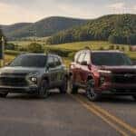 2026 Chevrolet Trailblazer and 2026 Chevrolet Traverse parked side by side on a rural Adams County, Ohio two-lane road surrounded by rolling summer farmland