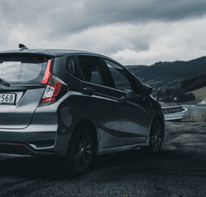 A certified pre-owned Honda parked outside by the road on a cloudy day