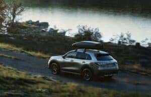 A gray 2024 Honda HR-V Sport dDriving on the road by a lake