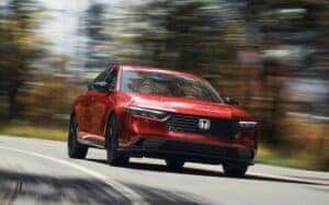 A red 2024 Honda Accord driving on the road