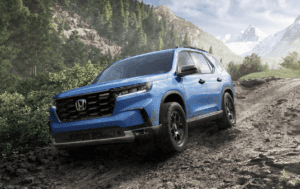 A blue 2024 Honda Pilot driving off road in the dirt