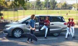 A mother and a baseball team leaving a 2024 Honda Odyssey minivan
