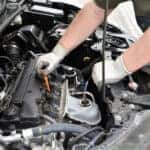 A service technician working on a Honda engine