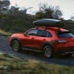 A red 2026 Honda HR-V SUV driving by a body of water