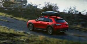 A red 2026 Honda HR-V SUV driving by a body of water
