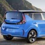 Backside view of the 2023 Kia Soul parked on a dirt part overlooking a forested mountain view.