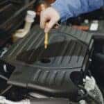 A service technician testing the oil of a car during a routine oil change