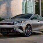 A gray 2024 Kia Forte GT with red accents driving on the road