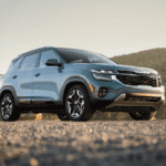 A blue 2024 Kia Seltos parked on gravel
