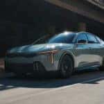 A turquoise 2025 Kia K4 driving on the road