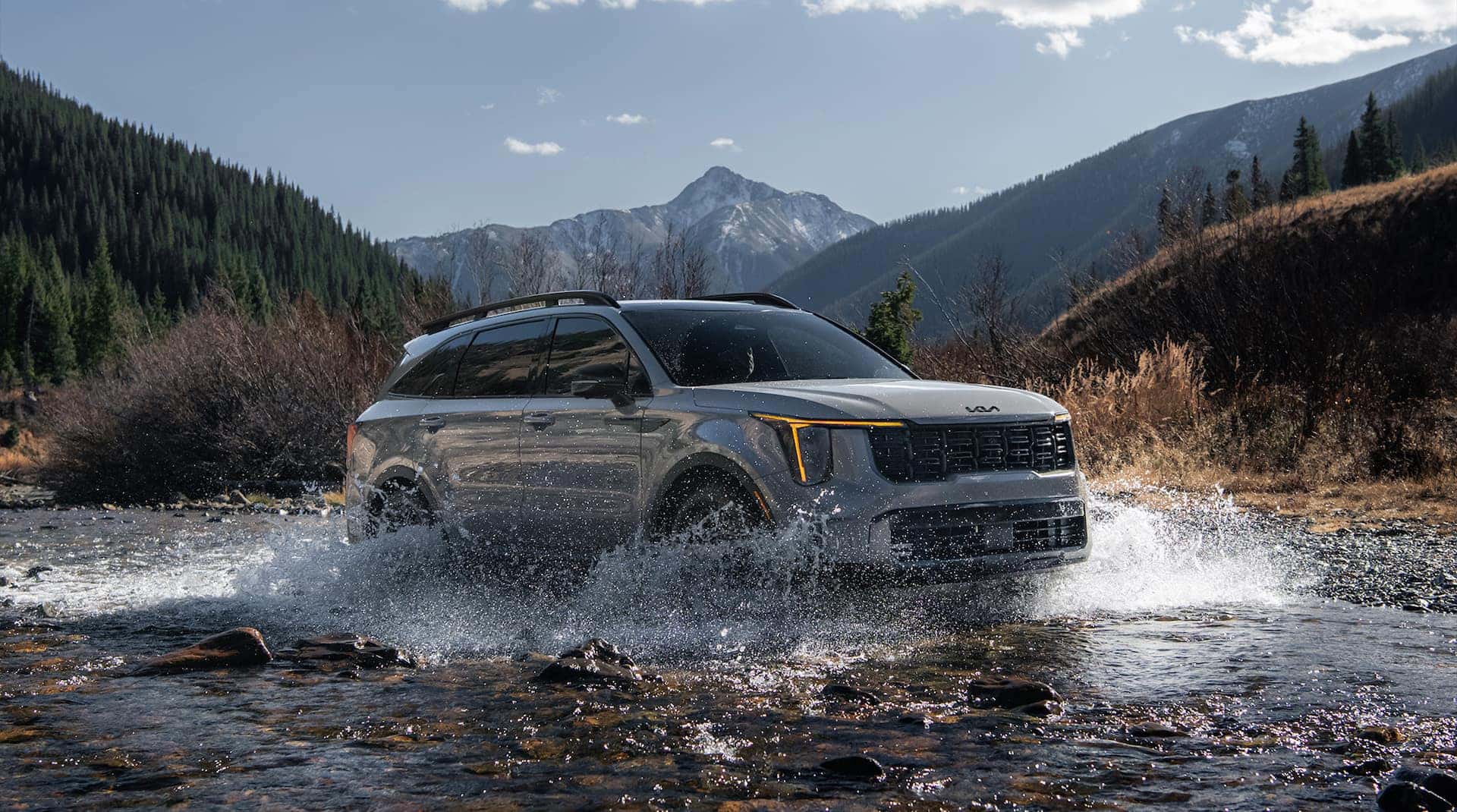 A gray 2025 Kia Sorento driving through the water in the mountains