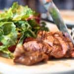 Man eating a salad with meat