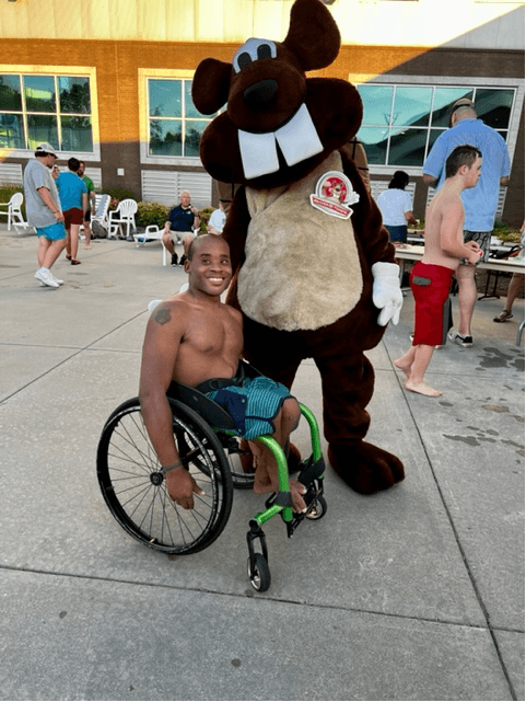 Bucky the Beaver at a pool party posing with a Miracle League kid