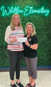 2 ladies holding a check presentation