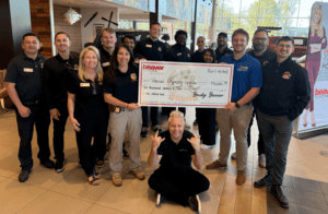 people standing beside check written for Special Olympics event