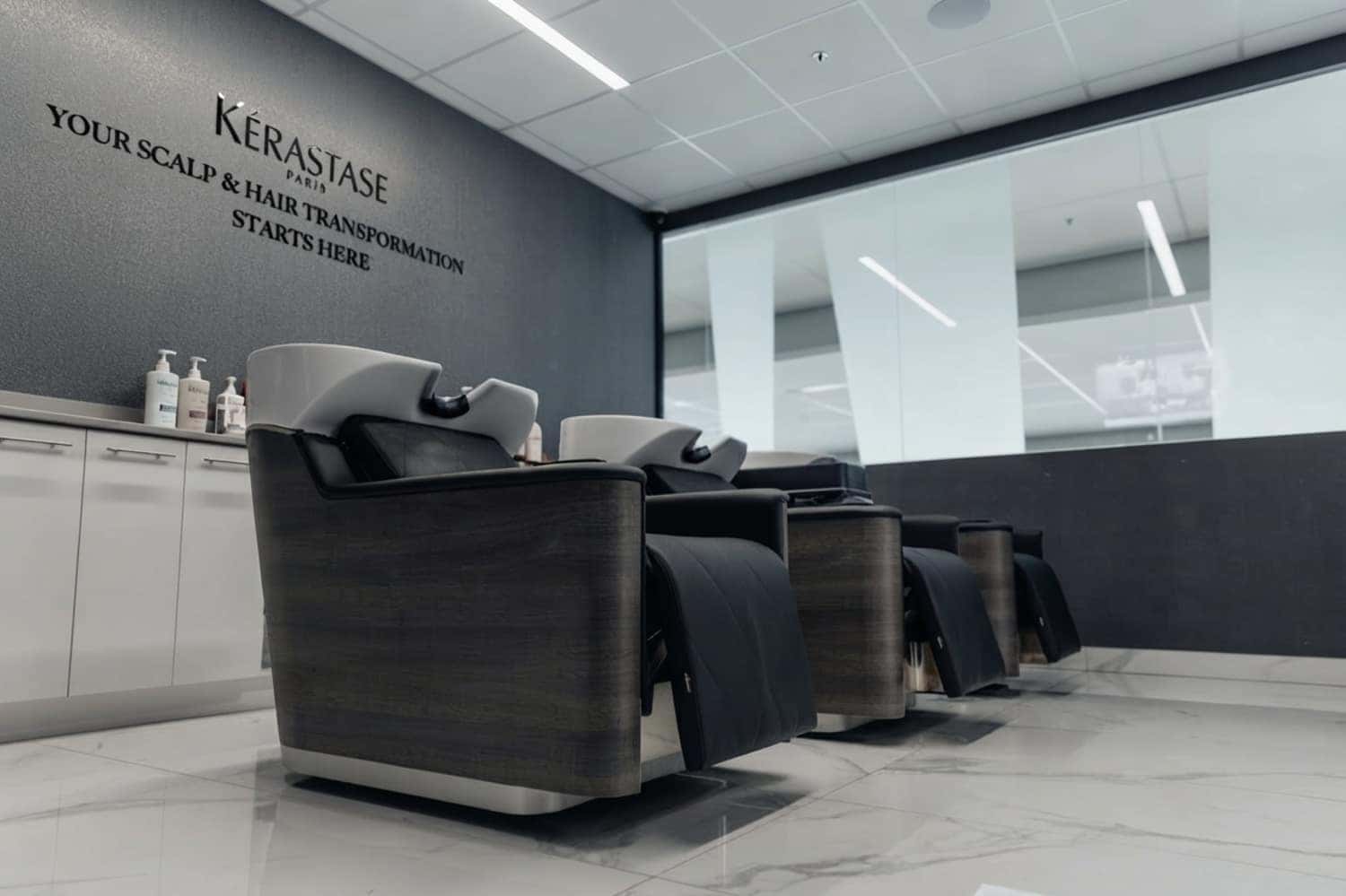 Crown and Co Salon wash stations featuring luxury black chairs, white ceramic basins, and the Kerastase brand wall display