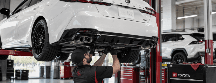 Toyota technician inspecting a Camry at a recall service center in Cumming, GA