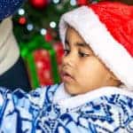 Young boy in Santa Hat helping with Christmas decorations