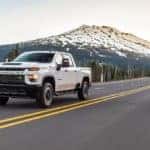 White 2020 Chevrolet Silverado 2500HD driving on a mountain freeway