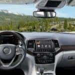 View from inside 2019 Jeep Grand Cherokee driver's seat looking at green hills