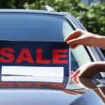 For sale sign on windshield of car.