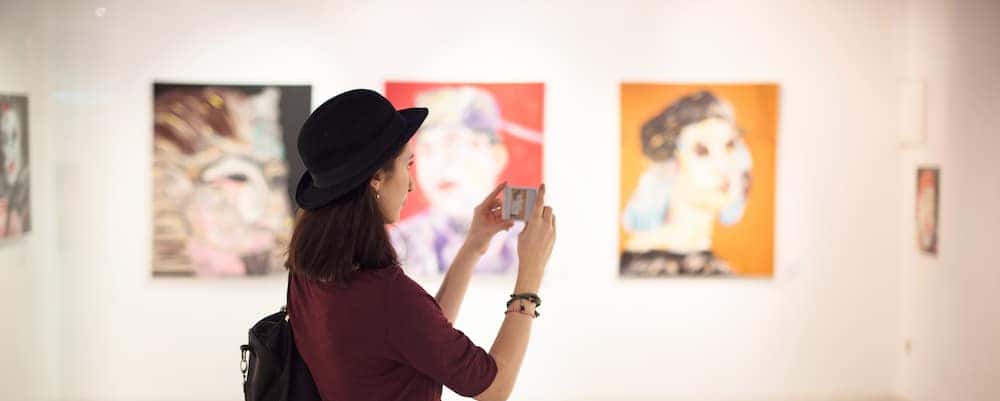 Lady in art museum taking a picture