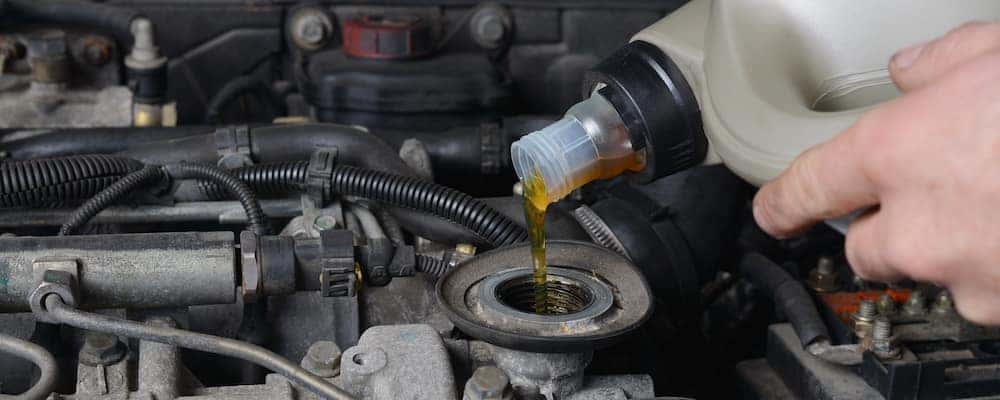 Pouring in new motor oil during oil change