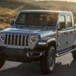 Silver 2020 Jeep Gladiator driving on highway at sunrise