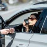 Woman blowing in breathalyzer
