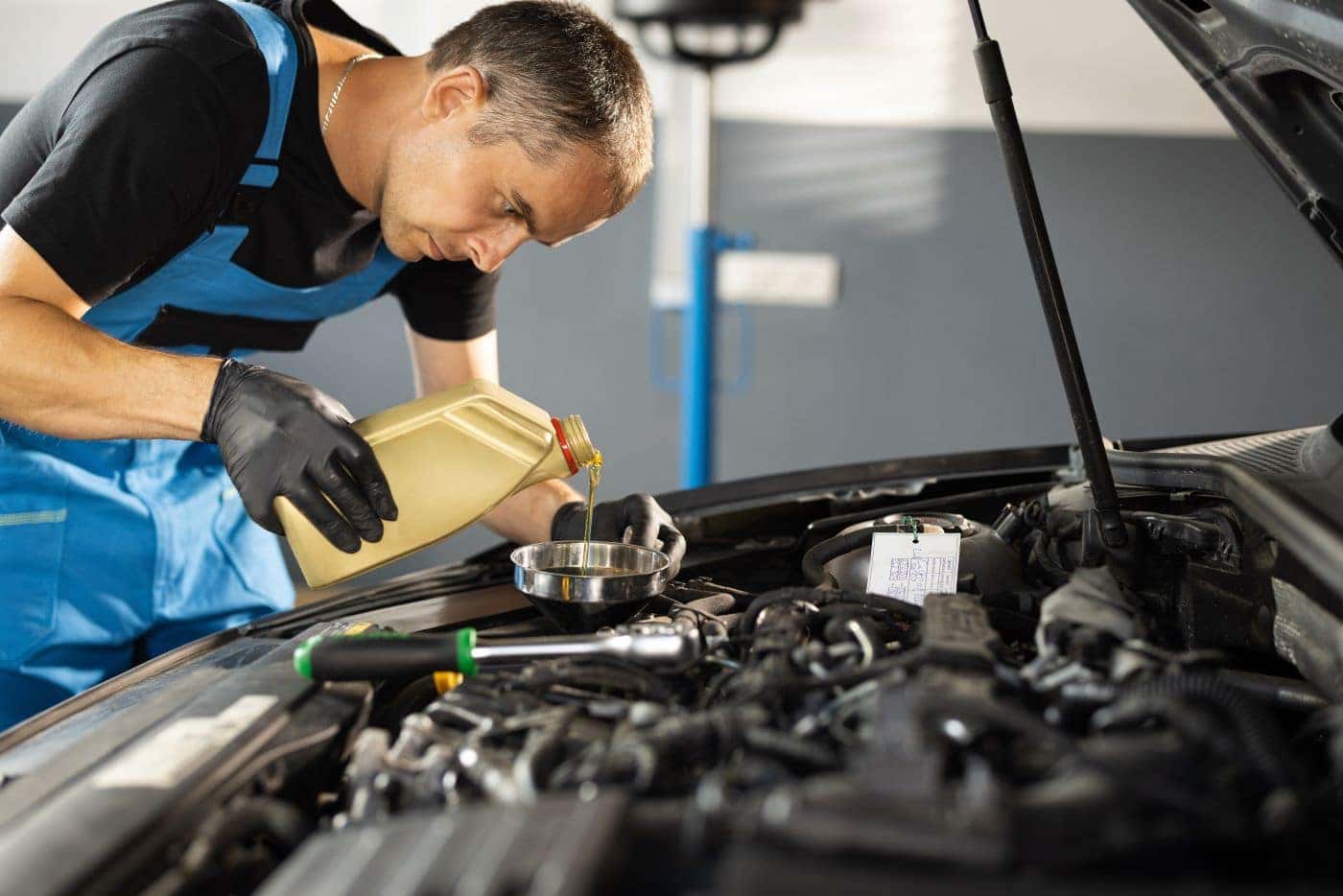 Honda Technician Pouring Oil Into Car