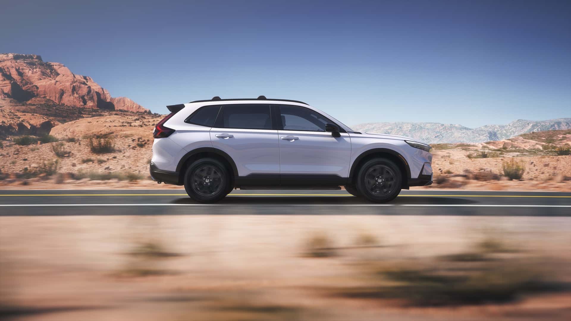 White Honda CR-V Sport Touring Hybrid driving along an open road